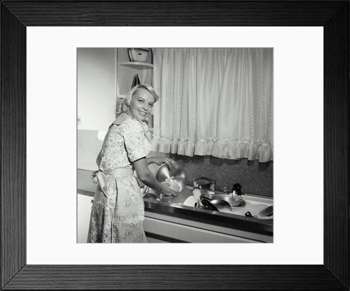 Framed Print : Portrait of a young woman washing pots and pans in a kitchen Framed Print : Portrait of a young woman washing pots and pans in a kitchen