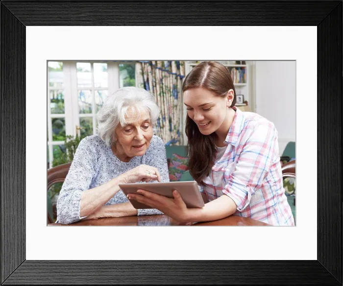 Framed Print : Teenage Granddaughter Showing Grandmother How To Use Digital Tablet Framed Print : Teenage Granddaughter Showing Grandmother How To Use Digital Tablet