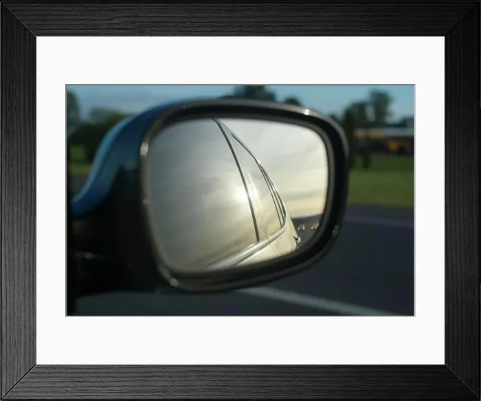 Framed Print : Car side mirror reflecting road and landscape under a soft, golden sunset. Oregon, USA