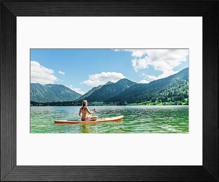 Framed Print : Young woman sitting on a Standup-Paddle Board or SUP Framed Print : Young woman sitting on a Standup-Paddle Board or SUP
