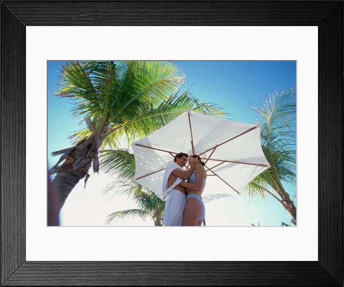 Framed Print : Low angle view of a young couple embracing on the beach Framed Print : Low angle view of a young couple embracing on the beach