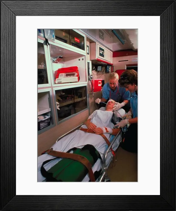 Framed Print : Two female emergency medical technicians attend to a patient in the back of an ambulance Framed Print : Two female emergency medical technicians attend to a patient in the back of an ambulance