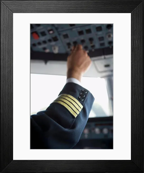 Framed Print : A pilot's hand using the control panel in the cockpit of a commercial airplane Framed Print : A pilot's hand using the control panel in the cockpit of a commercial airplane