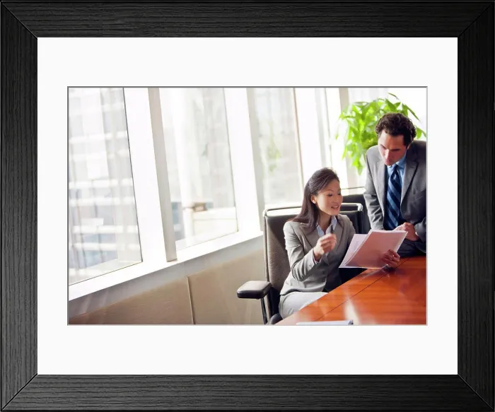 Framed Print : Two business colleague looking over important documents together Framed Print : Two business colleague looking over important documents together