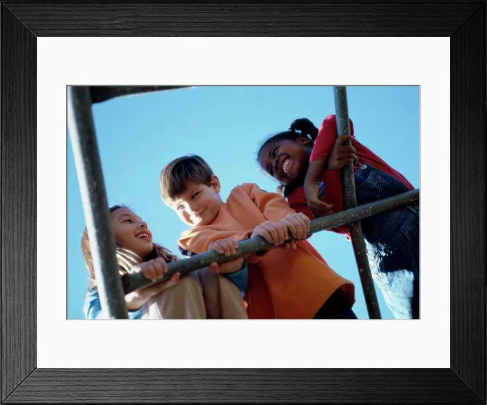 Framed Print : Low angle view of three children playing on a monkey bars