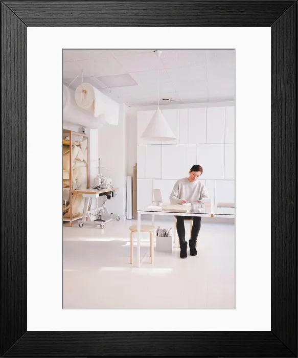 Framed Print : Full length of mature female design professional is writing in note pad at desk in workshop Framed Print : Full length of mature female design professional is writing in note pad at desk in workshop
