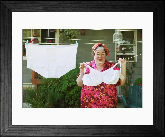 Framed Print : Woman hanging oversized underwear on a clothesline Framed Print : Woman hanging oversized underwear on a clothesline
