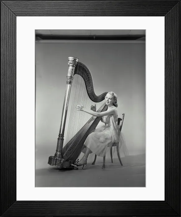 Framed Print : Vintage Photograph. Woman in dress sitting in chair playing Grand Pedal Harp. Frame 8 Framed Print : Vintage Photograph. Woman in dress sitting in chair playing Grand Pedal Harp. Frame 8
