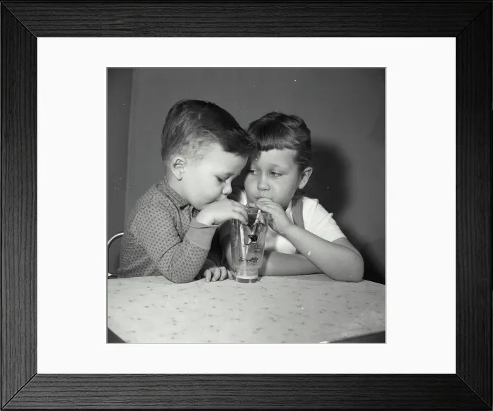 Framed Print : Vintage Photograph. Close-up of a boy and his sister sharing a glass of juice Framed Print : Vintage Photograph. Close-up of a boy and his sister sharing a glass of juice