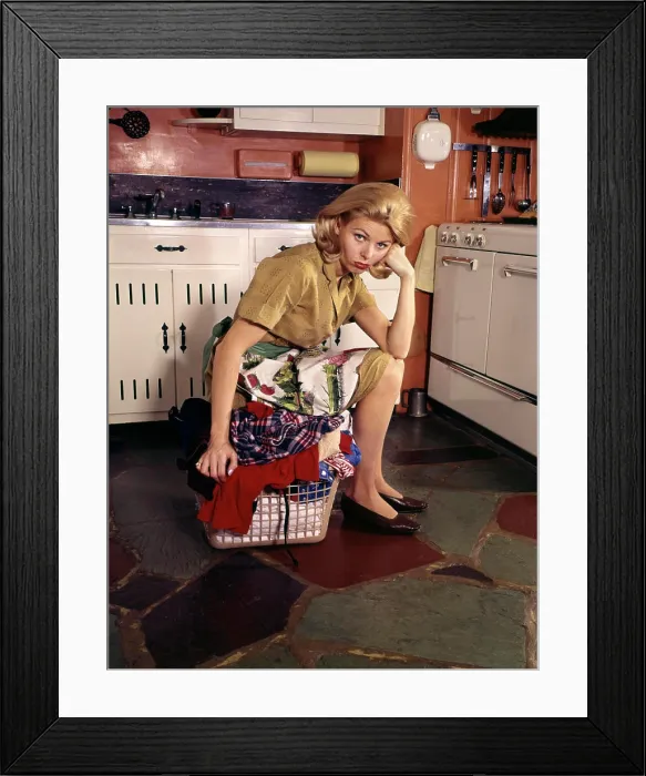 Framed Print : 1960S Weary Dejected Woman Housewife Homemaker Sitting On Full Laundry Basket In Kitchen