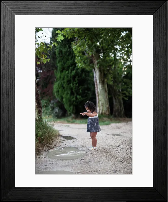 Framed Print : A little girl playing in a puddle Framed Print : A little girl playing in a puddle
