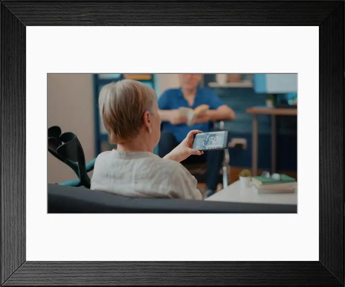 Framed Print : Old woman using smartphone to talk to family in hospital on videocall