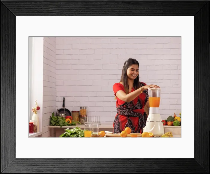 Framed Print : Woman making orange juice in kitchen Framed Print : Woman making orange juice in kitchen