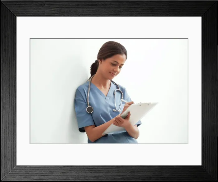 Framed Print : Young female surgeon writing notes isolated over white background Framed Print : Young female surgeon writing notes isolated over white background