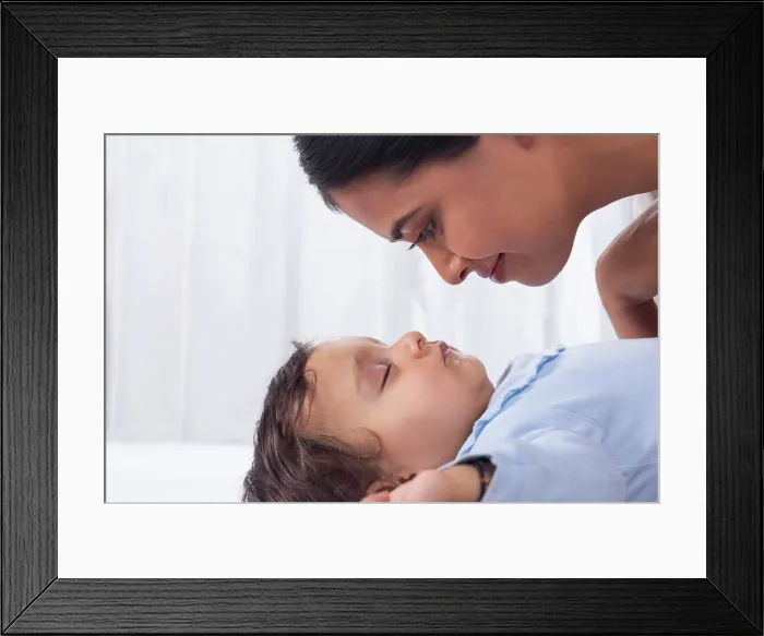 Framed Print : Portrait of mother looking at sleeping baby with affection