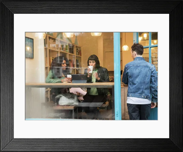 Framed Print : Two women sitting in window of cafe looking at tablet Framed Print : Two women sitting in window of cafe looking at tablet