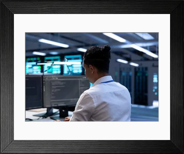 Framed Print : Admin in data center using diagnostic tools and system monitoring software on computer to identify root cause of errors