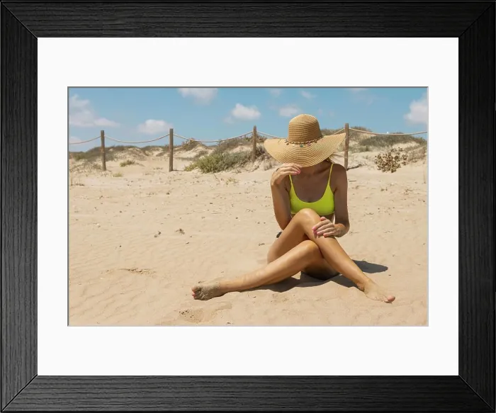 Framed Print : a girl in a swimsuit takes a photo on the beach with a hat, the most sporty place for inscriptions Framed Print : a girl in a swimsuit takes a photo on the beach with a hat, the most sporty place for inscriptions