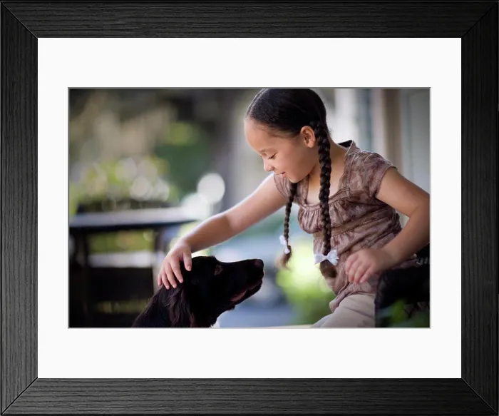 Framed Print : Young girl patting a dog on a porch