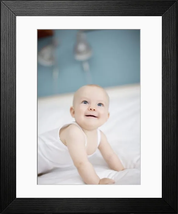 Framed Print : Portrait of a baby lying in a bed, Sweden Framed Print : Portrait of a baby lying in a bed, Sweden