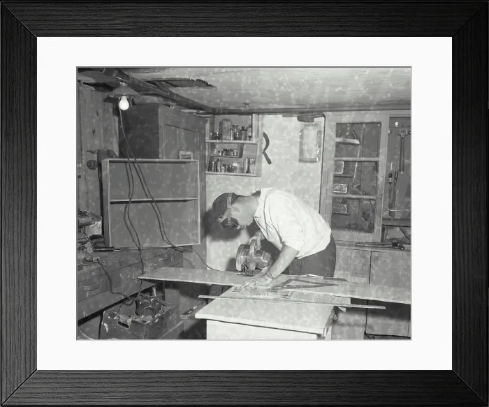 Framed Print : Vintage Photograph. A man cutting a piece of plywood. Frame 2