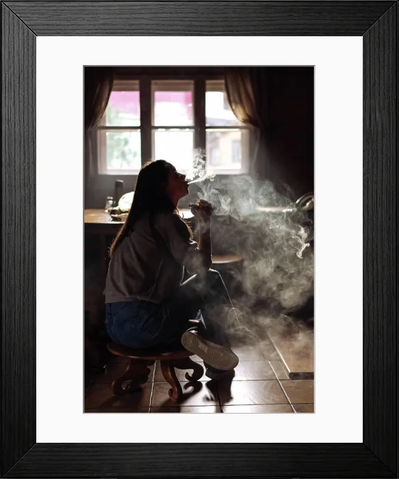 Framed Print : The girl smoke electronic cigarette Girl smokes an electronic cigarette by the window Framed Print : The girl smoke electronic cigarette Girl smokes an electronic cigarette by the window