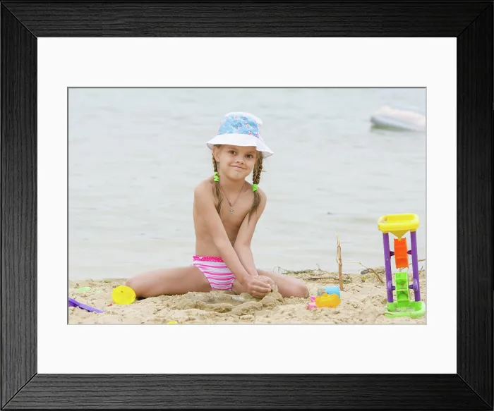 Framed Print : Five-year girl on a river in the sand beach Flashes Funny five-year girl playing with sand molds on the beach Framed Print : Five-year girl on a river in the sand beach Flashes Funny five-year girl playing with sand molds on the beach
