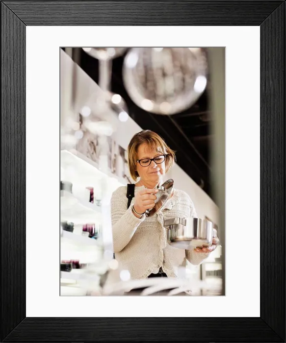 Framed Print : Senior woman buying cookware in shopping mall Framed Print : Senior woman buying cookware in shopping mall
