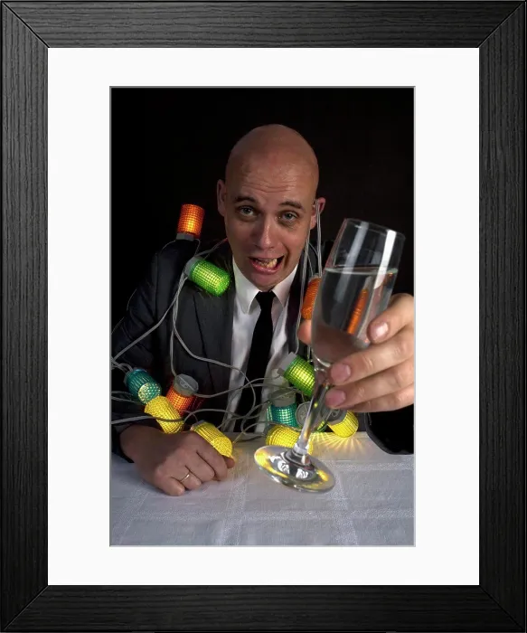 Framed Print : A drunk man with a string of lights around him holding a glass of champagne Framed Print : A drunk man with a string of lights around him holding a glass of champagne