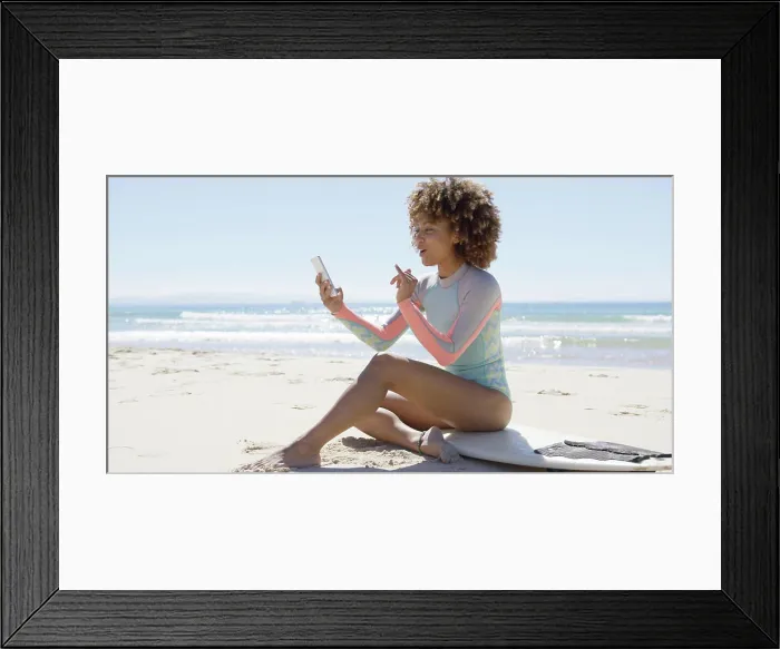 Framed Print : Smiling female on beach using smartphone Smiling female sitting on surfboard on beach using smartphone on sea Framed Print : Smiling female on beach using smartphone Smiling female sitting on surfboard on beach using smartphone on sea