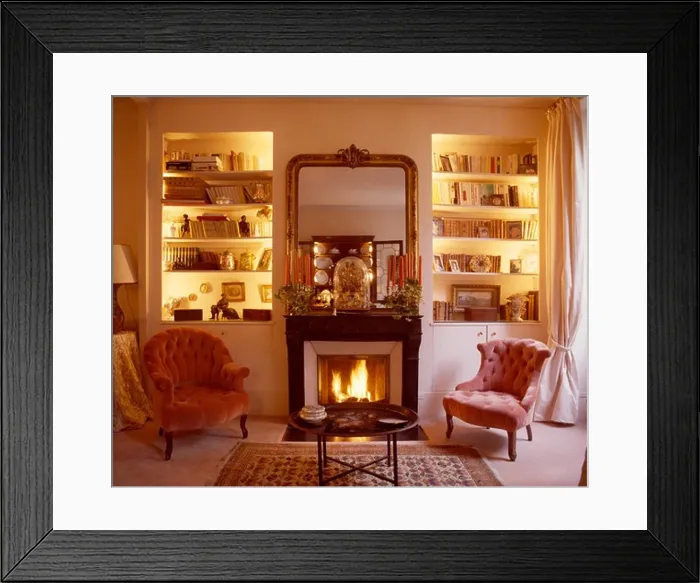 Framed Print : Lighted alcove shelves on either side of fireplace with lighted fire in living room with pink velvet chairs Framed Print : Lighted alcove shelves on either side of fireplace with lighted fire in living room with pink velvet chairs