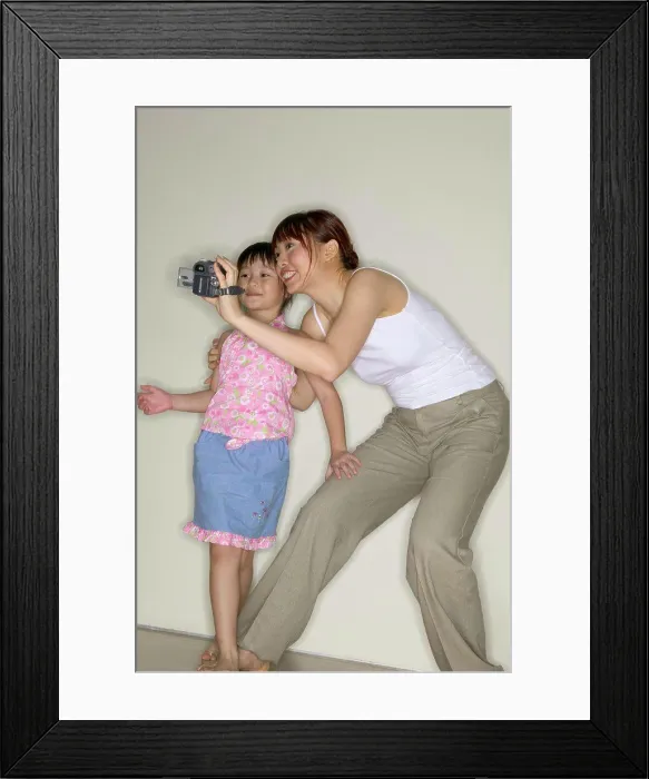 Framed Print : Mother and daughter using video camera Framed Print : Mother and daughter using video camera