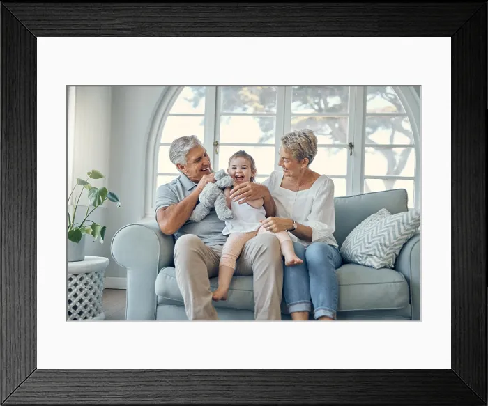 Framed Print : Happy family, grandparents and baby on sofa together talking Framed Print : Happy family, grandparents and baby on sofa together talking