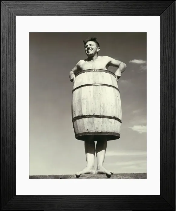 Framed Print : Low angle view of a young man wearing a barrel