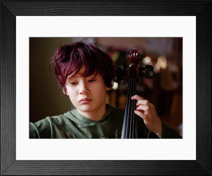 Framed Print : Close-up of serious boy with dyed red hair practicing cello music