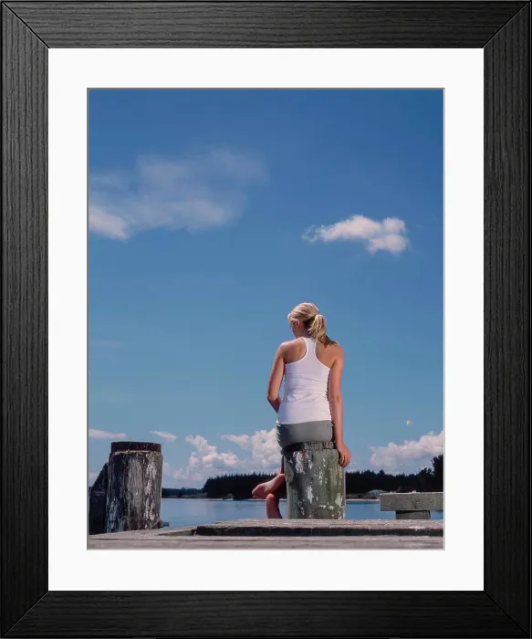 Framed Print : Back view of woman enjoying the view of coast from wharf Framed Print : Back view of woman enjoying the view of coast from wharf