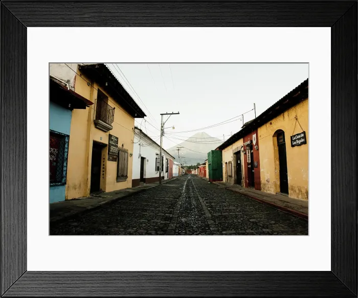Framed Print : A serene morning in a colorful, cobblestone street with a volcano looming in the distance Framed Print : A serene morning in a colorful, cobblestone street with a volcano looming in the distance