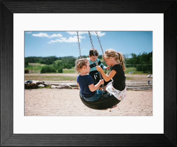 Framed Print : Children swing on tire on playset in mountains in sunshine Framed Print : Children swing on tire on playset in mountains in sunshine