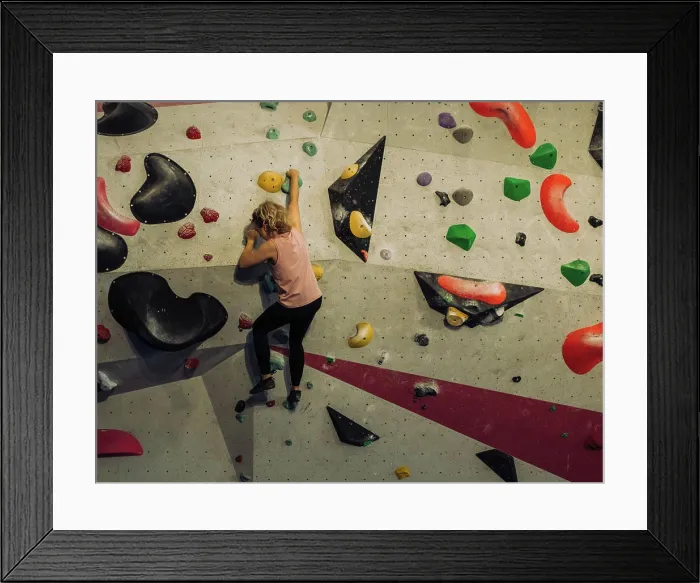 Framed Print : woman climbing a boulder wall indoors at a climbing centre Framed Print : woman climbing a boulder wall indoors at a climbing centre