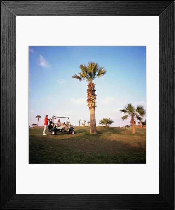 Framed Print : Man sitting on a golf cart with a woman standing behind him, Sharm el Sheikh, Egypt Framed Print : Man sitting on a golf cart with a woman standing behind him, Sharm el Sheikh, Egypt
