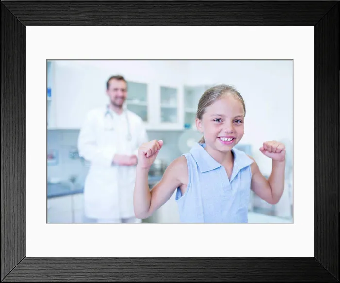 Framed Print : Portrait of girl cheering in doctor's surgery