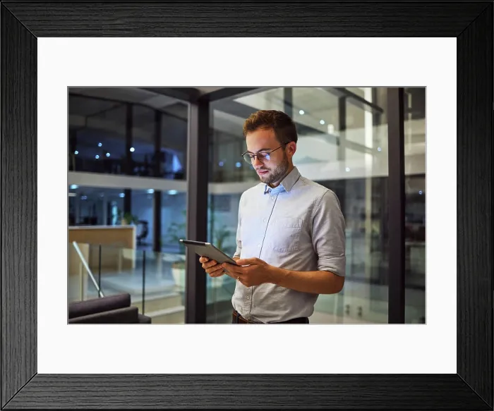 Framed Print : Businessman working on tablet at night for digital marketing online report at the office