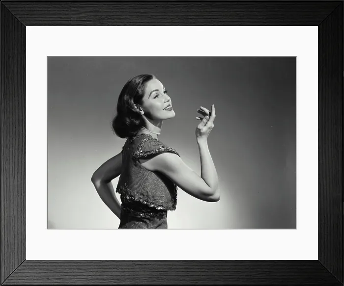 Framed Print : Vintage Photograph. Woman in vest holding up hand and smiling. Frame 1 Framed Print : Vintage Photograph. Woman in vest holding up hand and smiling. Frame 1