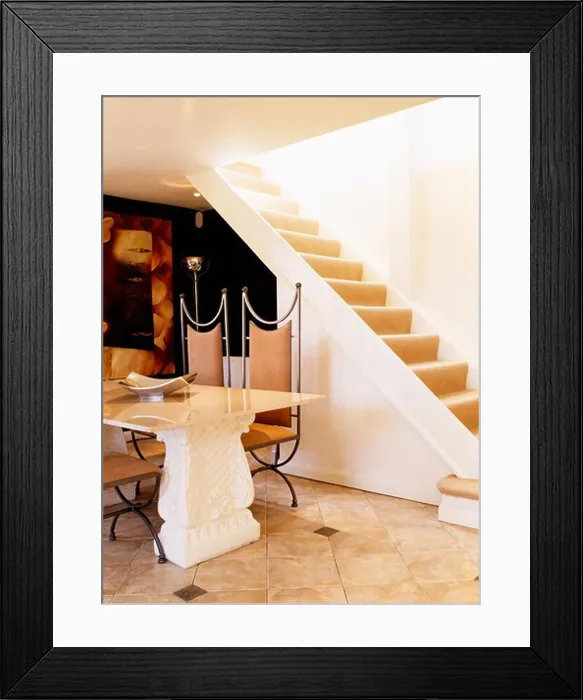 Framed Print : Stone table and leather and metal chairs in modern country hall with open staircase Framed Print : Stone table and leather and metal chairs in modern country hall with open staircase