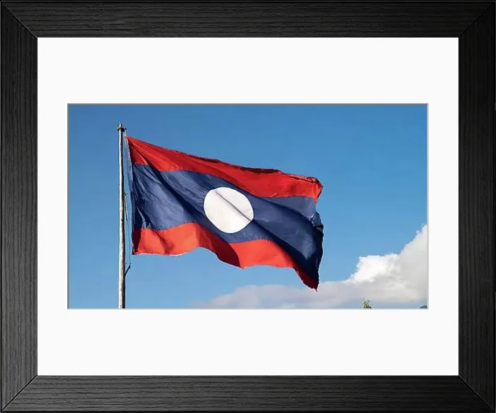 Framed Print : The flag of Laos flutters in the wind, isolated against a blue sky Framed Print : The flag of Laos flutters in the wind, isolated against a blue sky