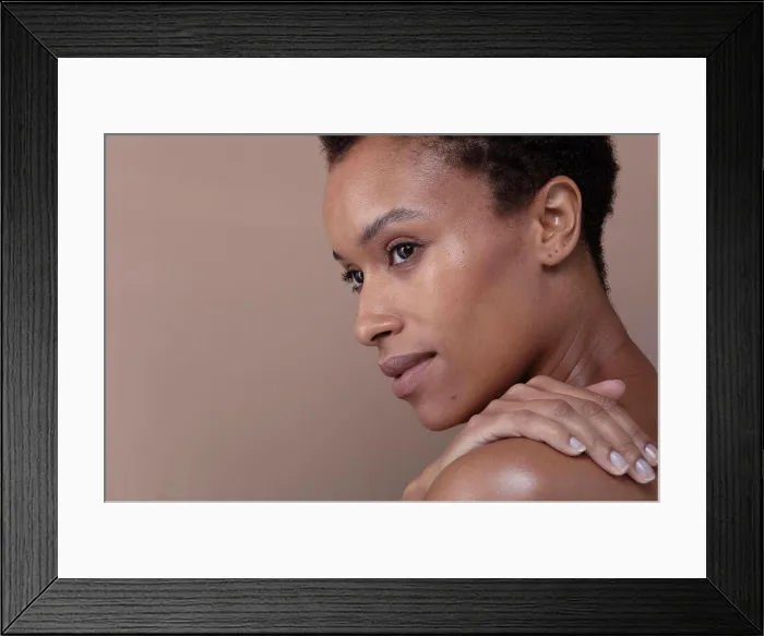 Framed Print : Studio shot of woman touching shoulder Framed Print : Studio shot of woman touching shoulder