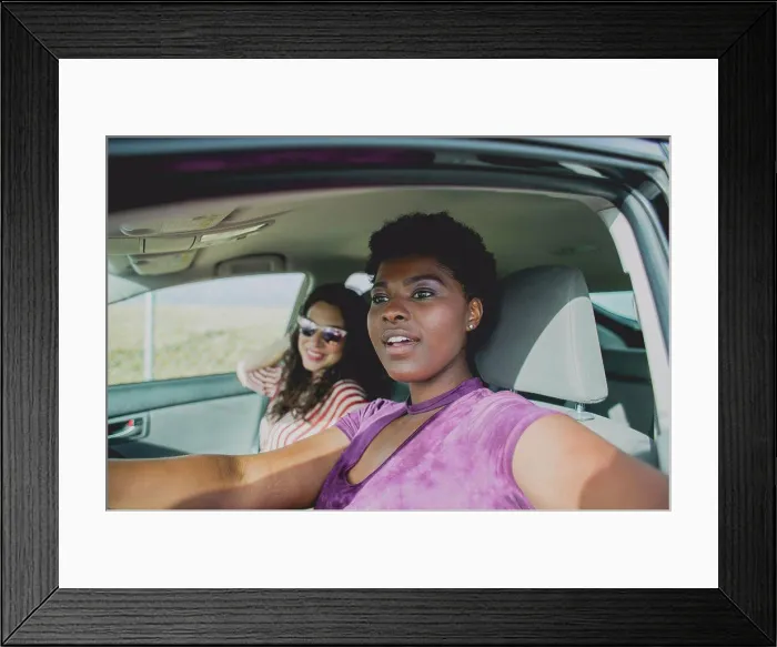 Framed Print : Young woman sitting with female friend looking away while sitting in car on sunny day Framed Print : Young woman sitting with female friend looking away while sitting in car on sunny day