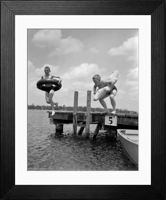 Framed Print : 1940S 1950S Two Boys Wearing Inflatable Inner Tubes About To Jump In Lake Off Pier Framed Print : 1940S 1950S Two Boys Wearing Inflatable Inner Tubes About To Jump In Lake Off Pier