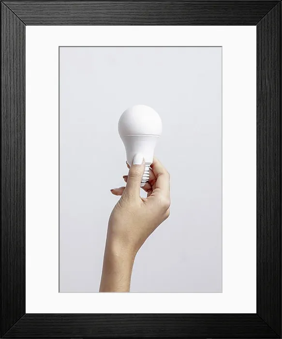 Framed Print : Front view hand holding light bulb with copy space