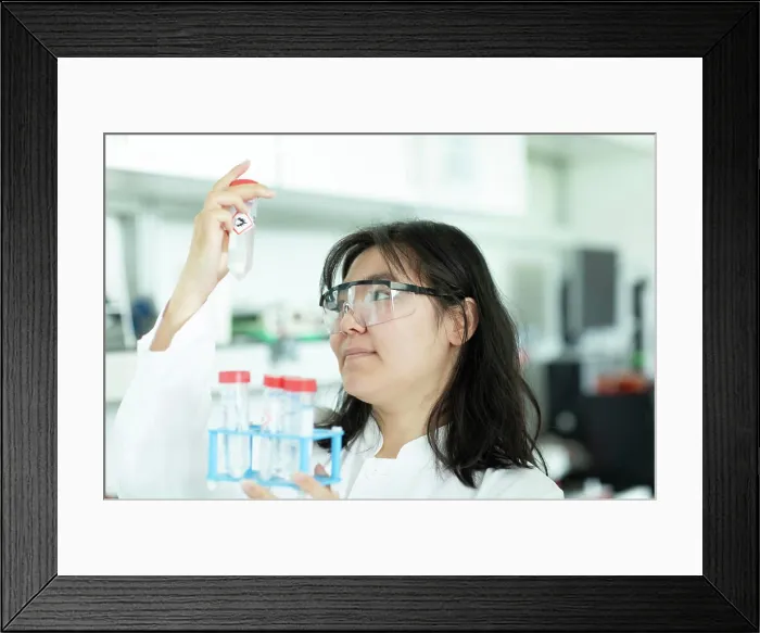 Framed Print : young scientist female controlling a tube of a rack Framed Print : young scientist female controlling a tube of a rack